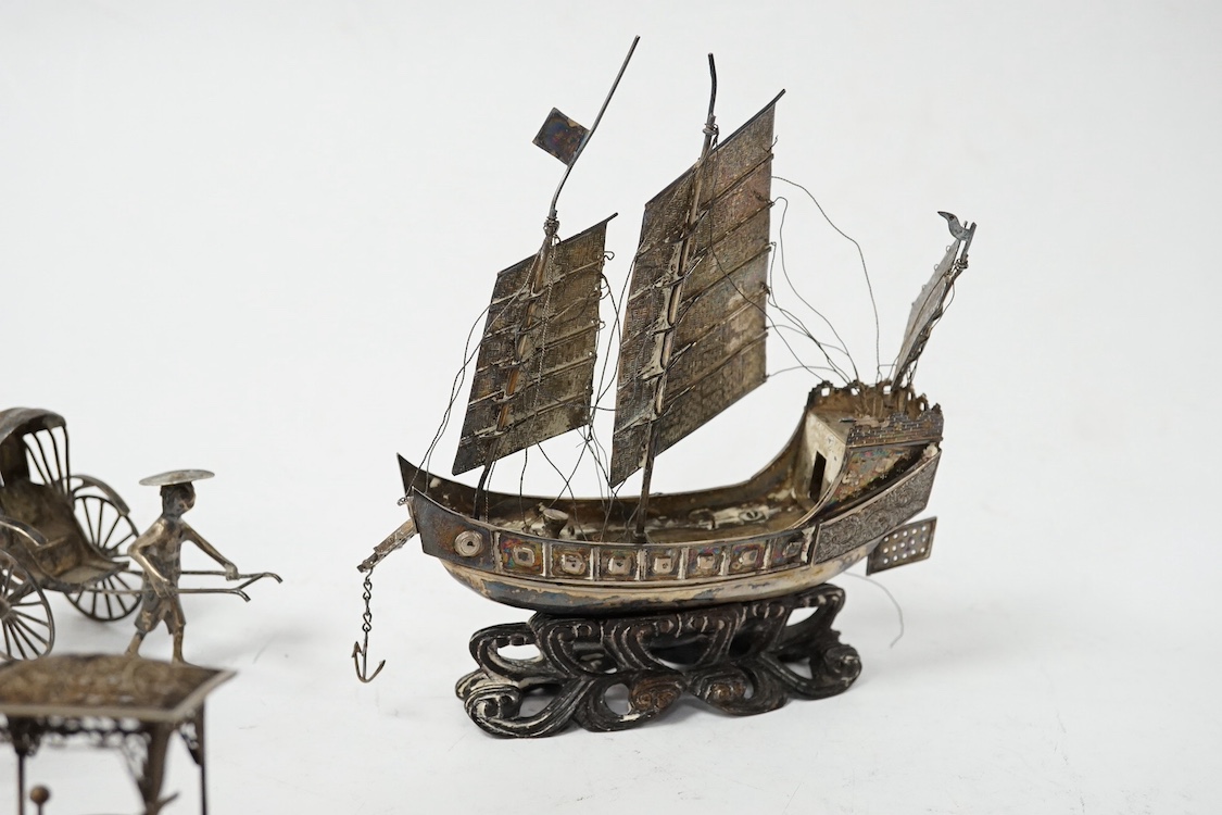 A Chinese white metal miniature model of a junk, length 11.2cm, on a wooden stand, a similar late 19th/early 20th century miniature filigree sedan chair and rickshaw by Kwan Wo and a Chinese white metal model of a boat w